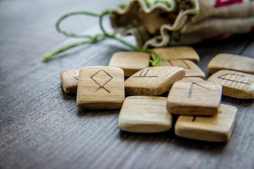 Ancient runes, canvas bag with embroidery on old vintage wooden background. Selective focus.