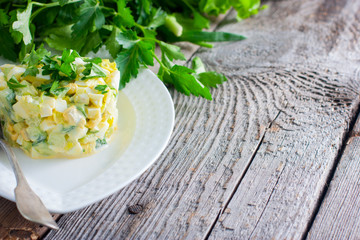 Salad with fresh vegetables and eggs on a wooden table with fresh herbs, copy space