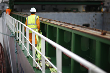 Port workers dragged slings for loading on board ship cargo ship