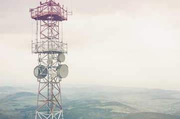 Radio mast over a cloudy valley background