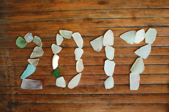 Seaglass decor on wooden background. 2017 New Year sea glass mosaic - Powered by Adobe