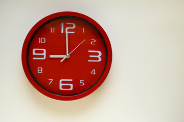 Modern red clock with white background.