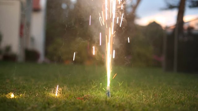 Lighting a firework in a suburban backyard Home firework during new year