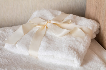 Stacked white spa towels with bow. Present for women
