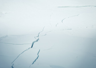 A beautiful cracked ice along the frozen river in Norwegian winter