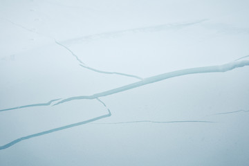 A beautiful cracked ice along the frozen river in Norwegian winter