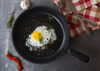 fried eggs iron frying pan rosemary spice pepper
