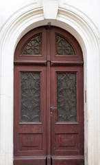 Old vintage wooden brown door close-up with insertions and patterns on glass