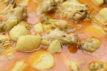 Closeup shot of yellow curry with chicken.