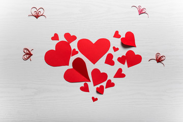 Wooden white background with red hearts. The concept of Valentin