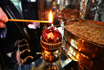 woman lights the candle at a greek Orthodox church 