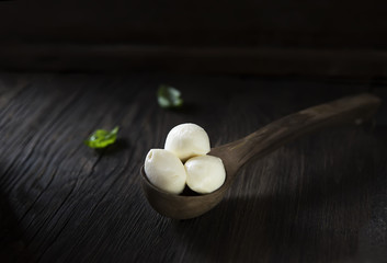mini mozzarella and basil on a wooden background