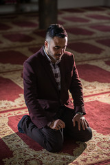 Obraz premium Humble Muslim praying while kneeling