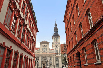 Church in the Baroque style in the street with red historical buildings. Wroclaw, Poland.