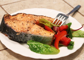 Healthy eating background. Grilled salmon slice grilled in white plate with salad. Close-up view.