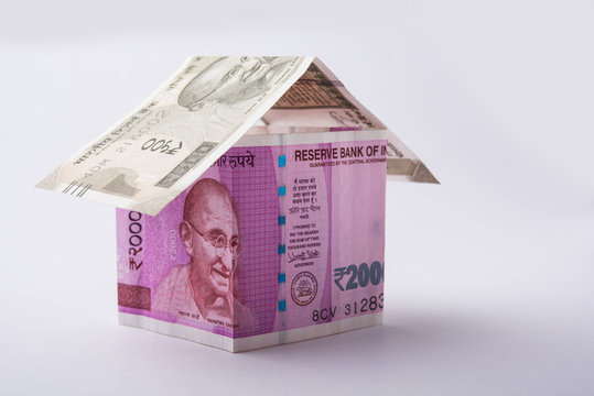 Indian Real Estate Business concept showing 3D Model home made using paper currency notes, Isolated over colourful background. Selective focus