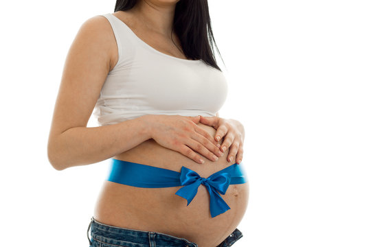 the midsection of the young pregnant woman with Blue Ribbon close-up