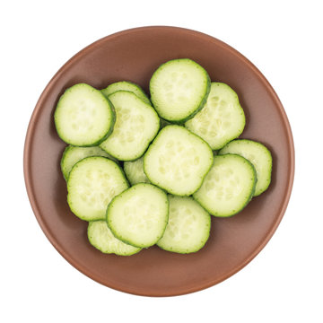 Fresh sliced cucumber in a brown plate. Isolated on white background.