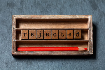 Rejected decline decision concept. Vintage box, wooden cubes with old style letters, red pencil....