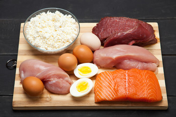 Proteins, fish, cheese, eggs, meat and chicken on a black background - 139246013