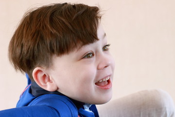 Smiling beautiful boy close-up face portrait in blue shirt.