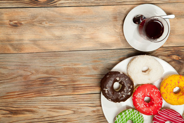 Cup of tea and donuts on a wooden background