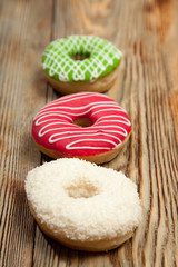 Colorful donuts on wooden background