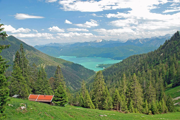 Fototapeta na wymiar Beautiful panorama of Walchensee in the bavarian alps with a red hut in the front