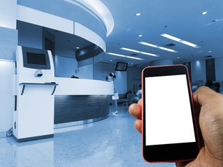 Phone on hand with interior hospital background, blank space, copy space, blue color tone .