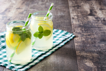 Lemonade drink in a jar glass on wooden background. Copyspace.
