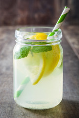 Lemonade drink in a jar glass on wooden background. Copyspace.
