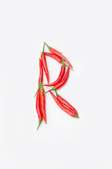 Bold letter R Latin alphabet of red hot chili pepper on a white background