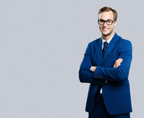 Obraz na płótnie Canvas young businessman in glasses, against grey