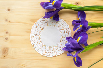 gift on white napkin and three irises on wooden background