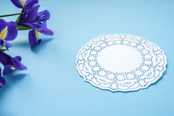 gift on white napkin and three irises on blue background