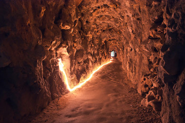 Underground tunnel in Quinta da Regaleira with lighting. Mystical cave.