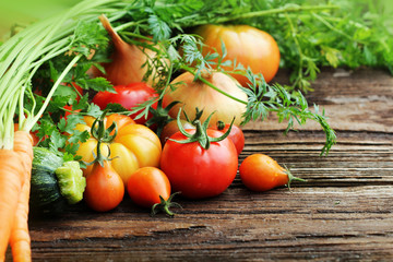 Vegetables and herbs on wooden background.