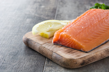 Raw salmon fillet on wooden background
