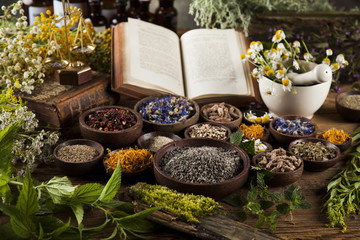 Book and Herbal medicine on wooden table background