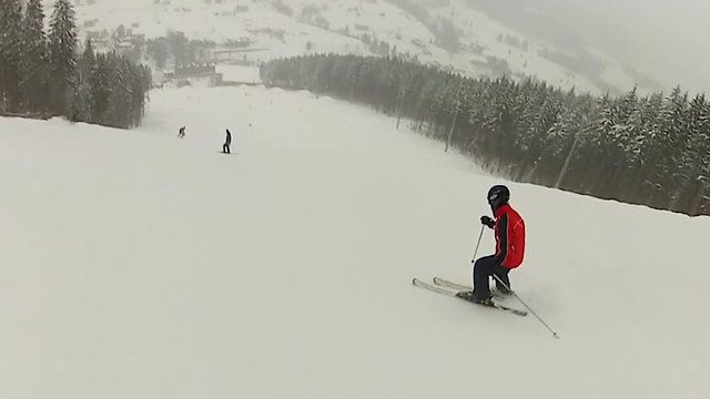 Private skiing coach riding down snowy mountain slope, demonstrating tricks