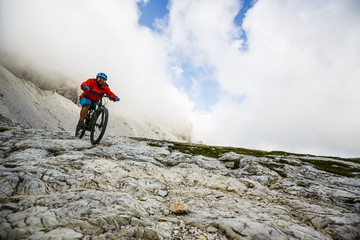 Obraz premium View of cyclist riding mountain bike on trail in Dolomites,Tre Cime di Laverado, South Tirol, Italy