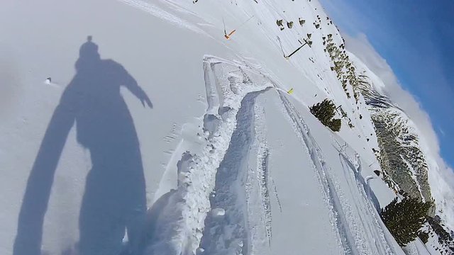 Shadow of snowboarder rushing down track on snowy mountain slope, extreme sport