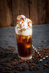 Cold coffee drink frappe (frappuccino), with whipped cream and caramel syrup, with straws and...