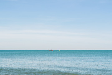 A lonely boat in the water of Mediterranean sea on sunny day at Malaga, Andalusia, Spain.