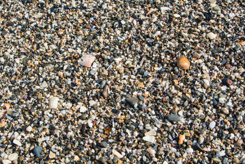 Close up view of beach with small stones, sand and shells at Malaga, Andalusia, Spain.