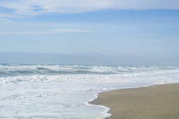 Sea waves with foam at the shore of national park Cabo de Gata near Almeria, Andalusia, Spain.