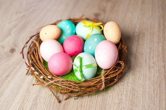 Easter composition of the branches, cakes, tulips colored eggs cooked for the holiday on the wooden background with free space for an inscription