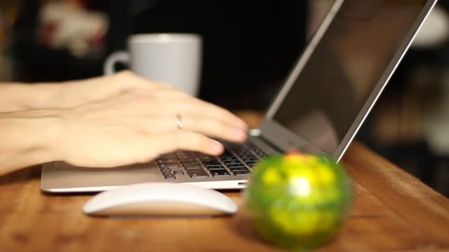 A man typing on a laptop keyboard. Wrist pain. 