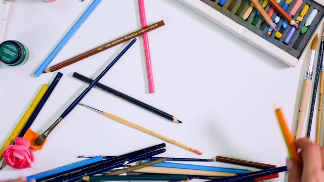Designer, artist workspace. Hands remove objects on the table, leave blank area for you. Top view. 4K.