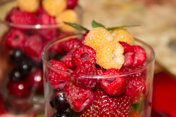 Yellow and red raspberries in a glass.